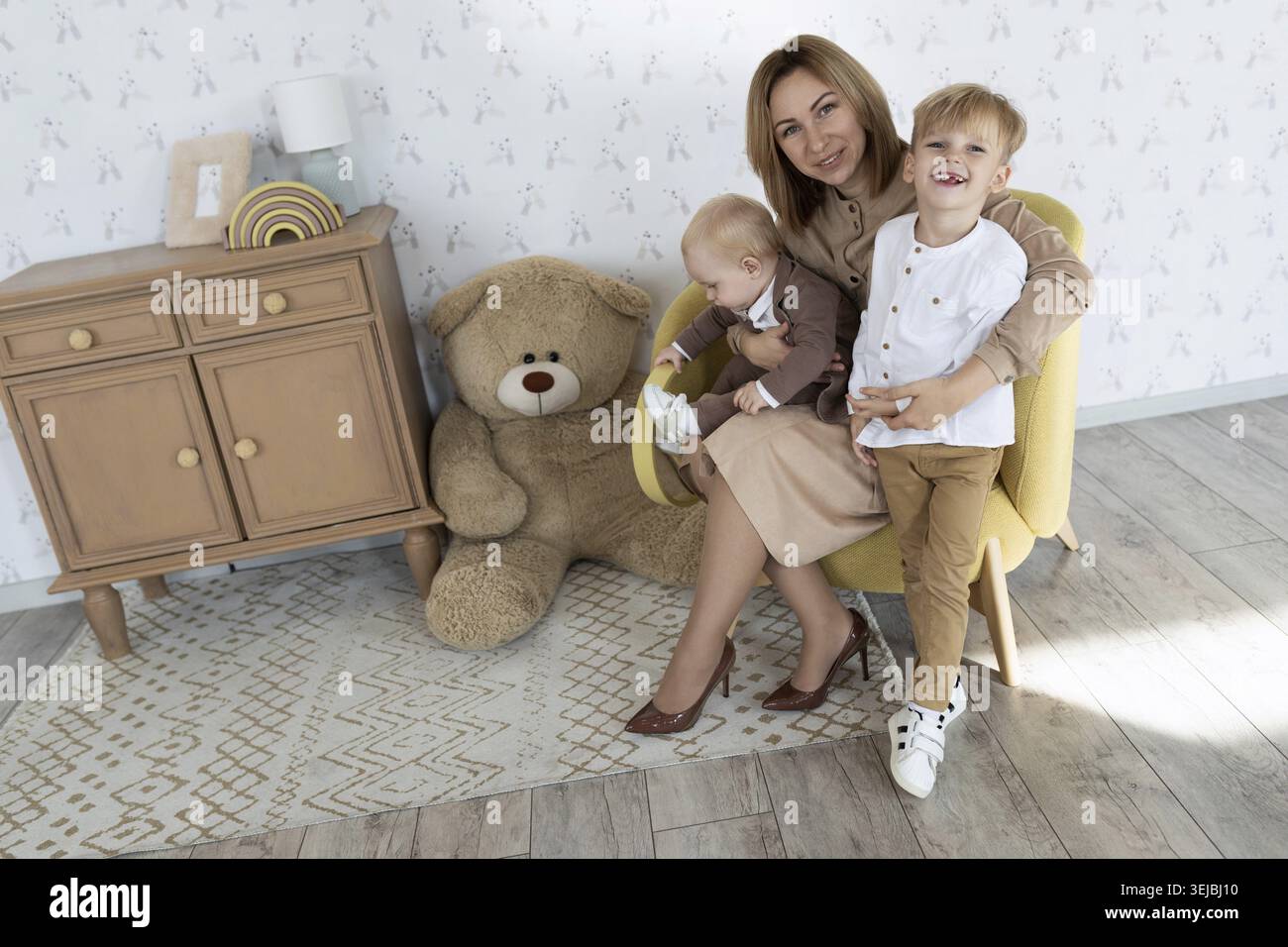Happy mom with two male children in the children's room having fun Stock Photo