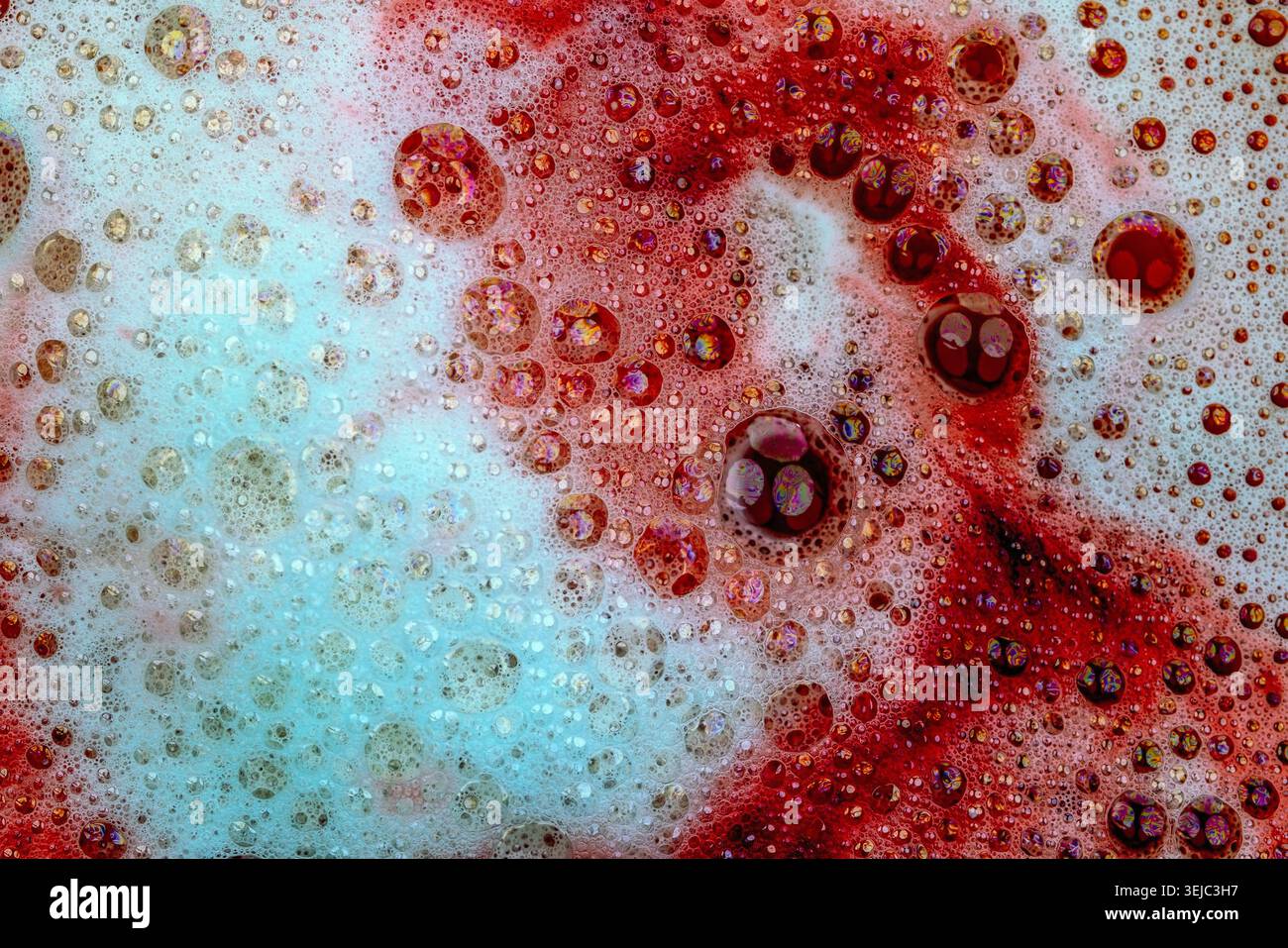 Detergent foam with bubbles and colored bubbles in red liquid Stock Photo