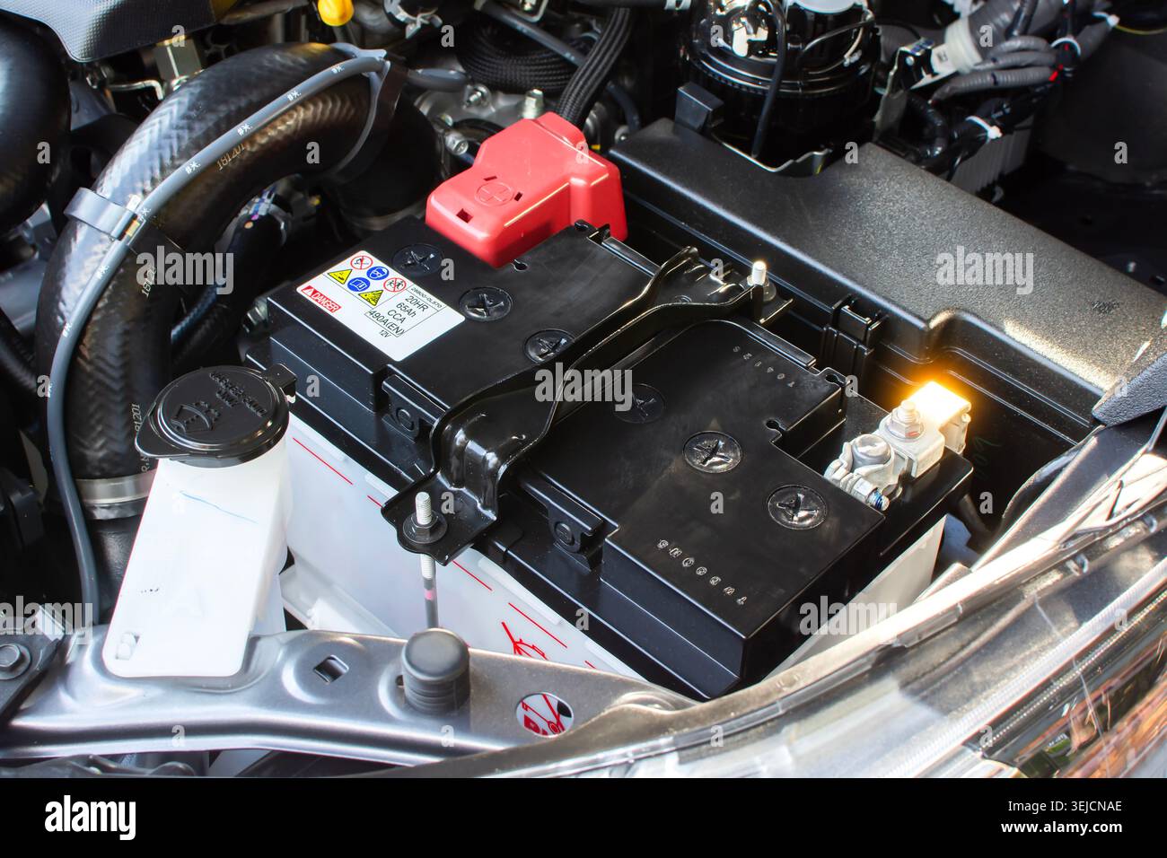 A new 12V car battery installed inside a vehicle engine bay Stock Photo ...