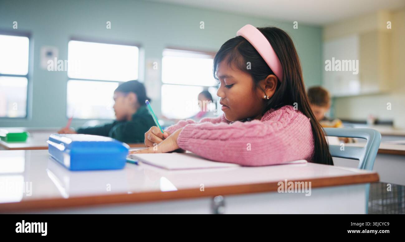 Writing, assessment and exam with kids in classroom for test, child development and knowledge. Education, notebook and lesson with students on school Stock Photo