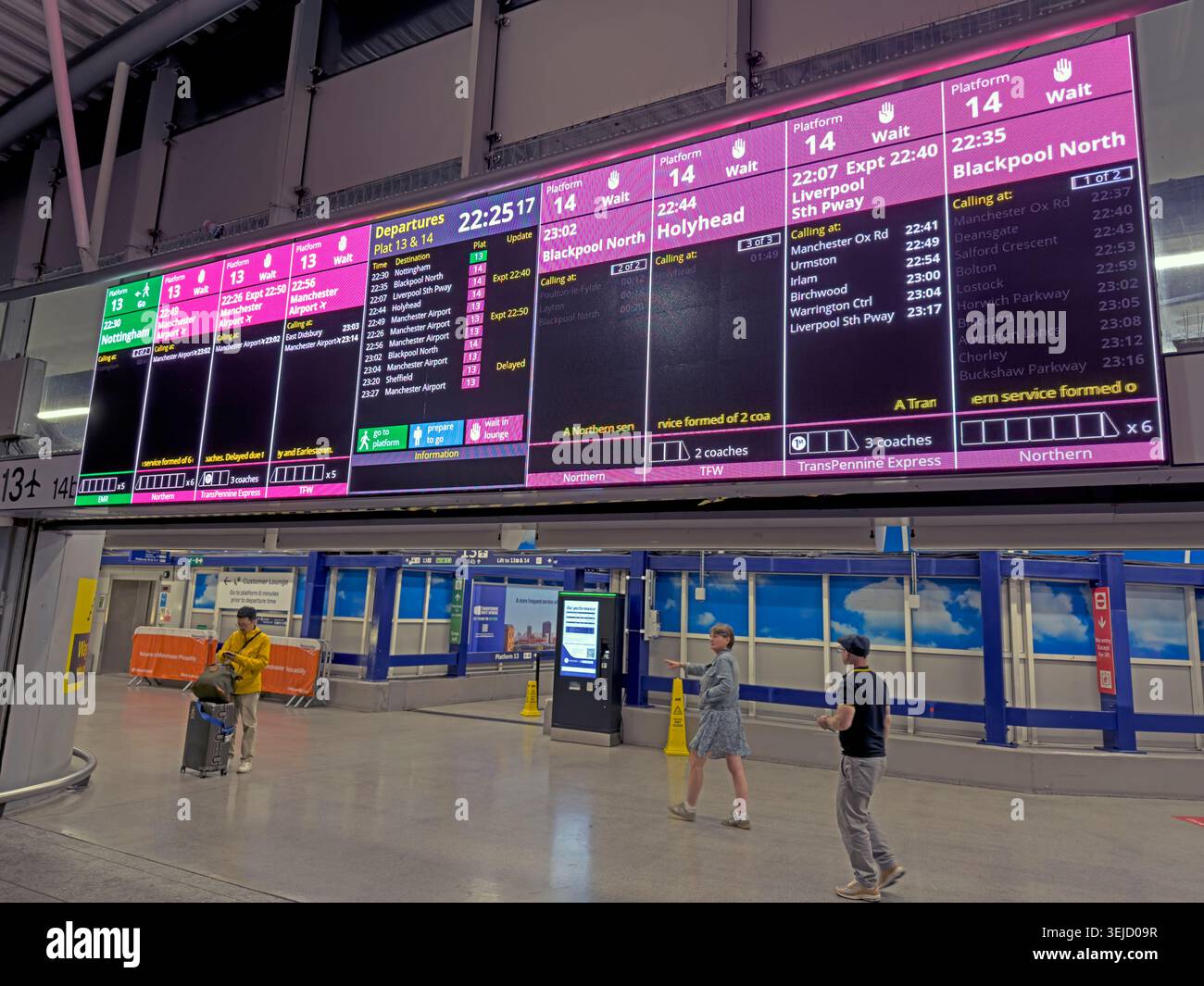 Passengers check digital screens delayed services at congested Manchester Piccadilly platforms 13 and 14, a notorious Castlefield Corridor bottleneck. Stock Photo