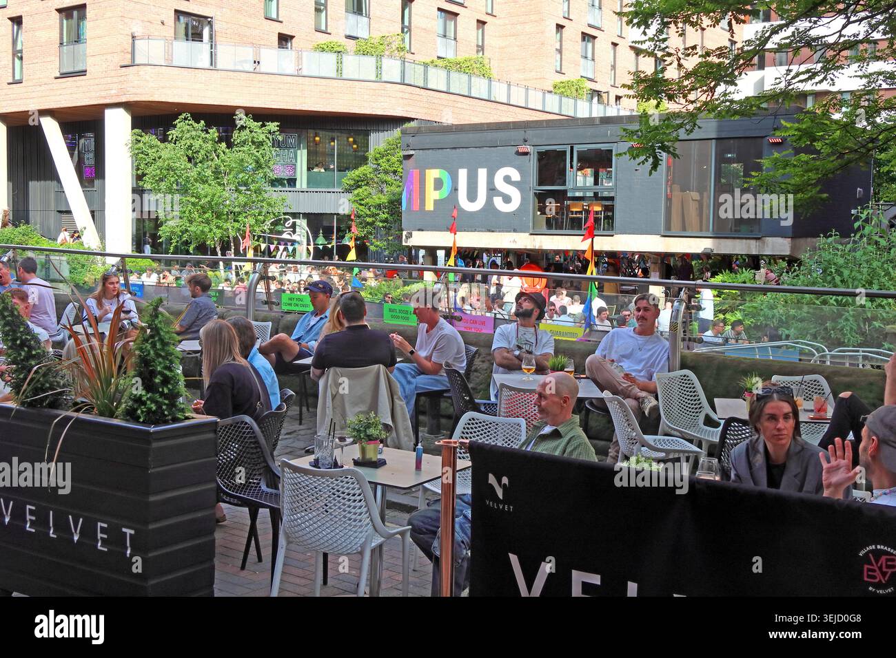 Outdoor drinkers at Velvet with Kampus opposite in Manchester’s LGBTQ+ quarter on Canal Street, in the gay village area Stock Photo