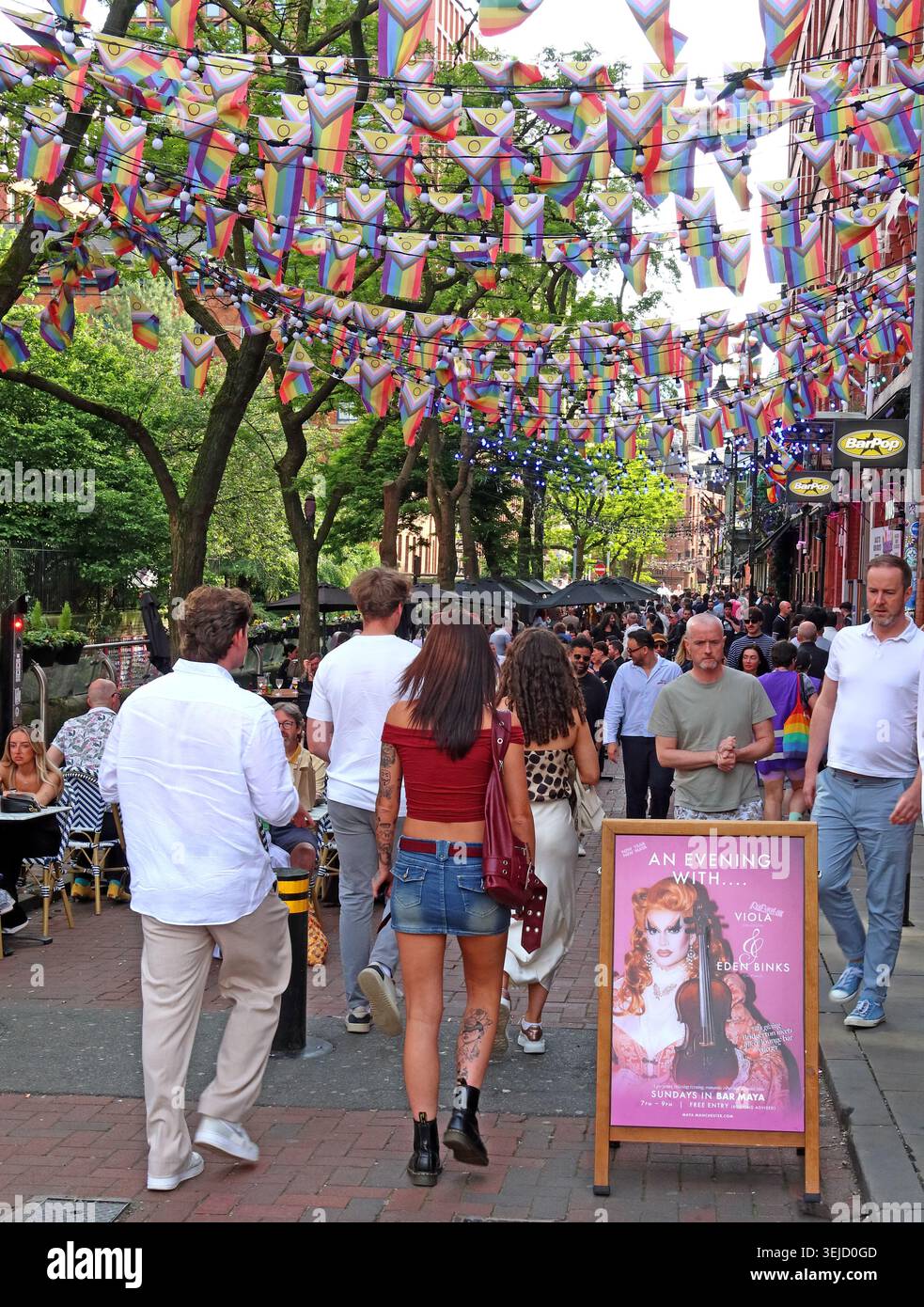 Drag act poster and Pride bunting on Canal Street, Manchester, as crowds enjoy outdoor bars in the Gay Village. Stock Photo
