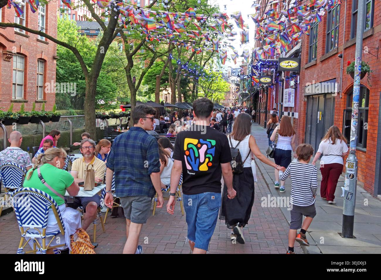 Warm spring sunshine, Visitors and outdoor drinkers fill Canal Street, Manchester, in the city’s LGBTQ+ bar and club quarter. Stock Photo