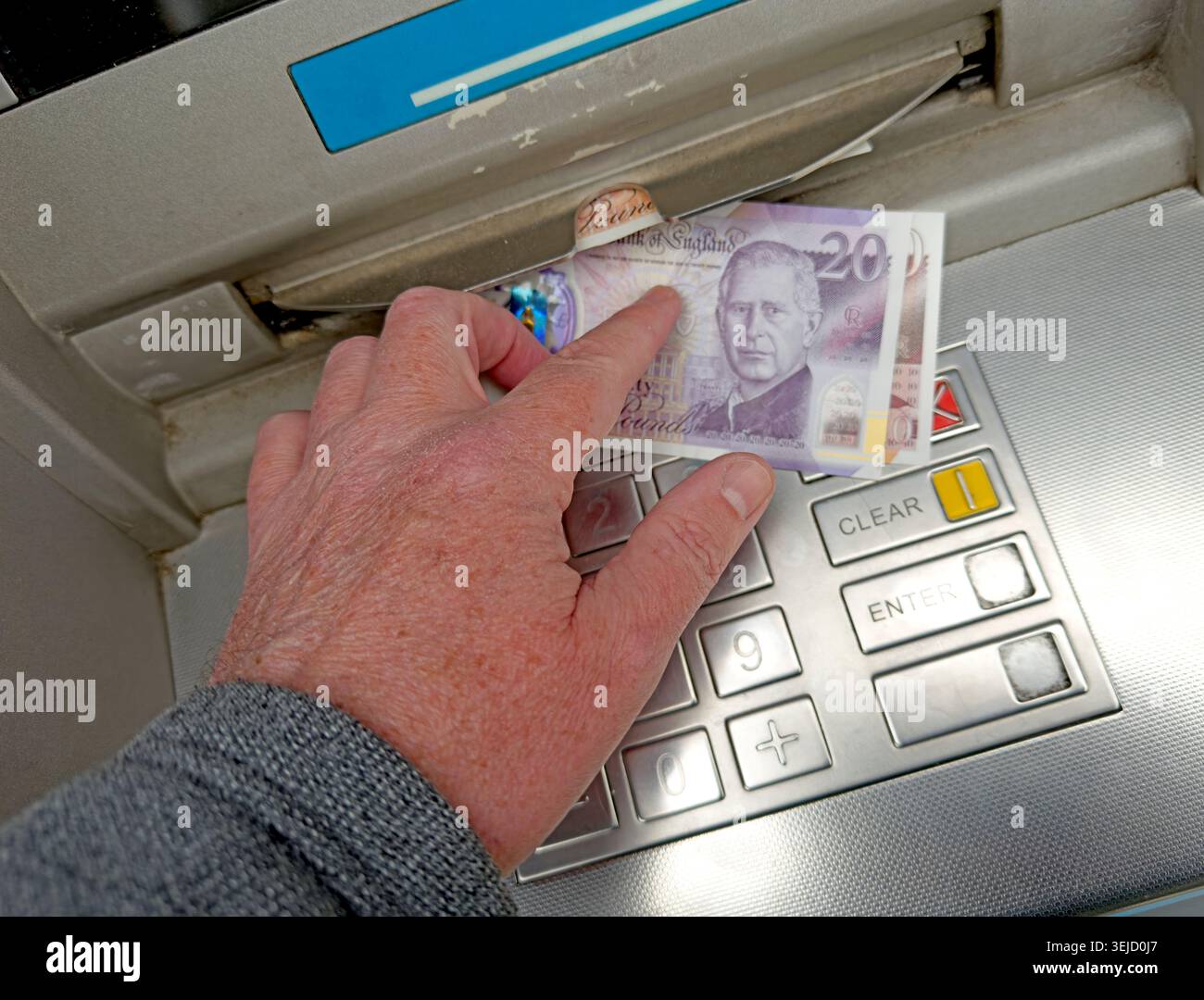 Atm Open Note Hand removes a new Charles III polymer £20 note from an ATM ...