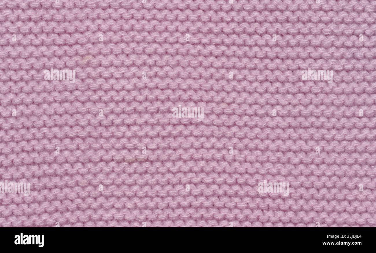 Knitted fabric made of pink wool threads, pigtail pattern, full frame. Stock Photo