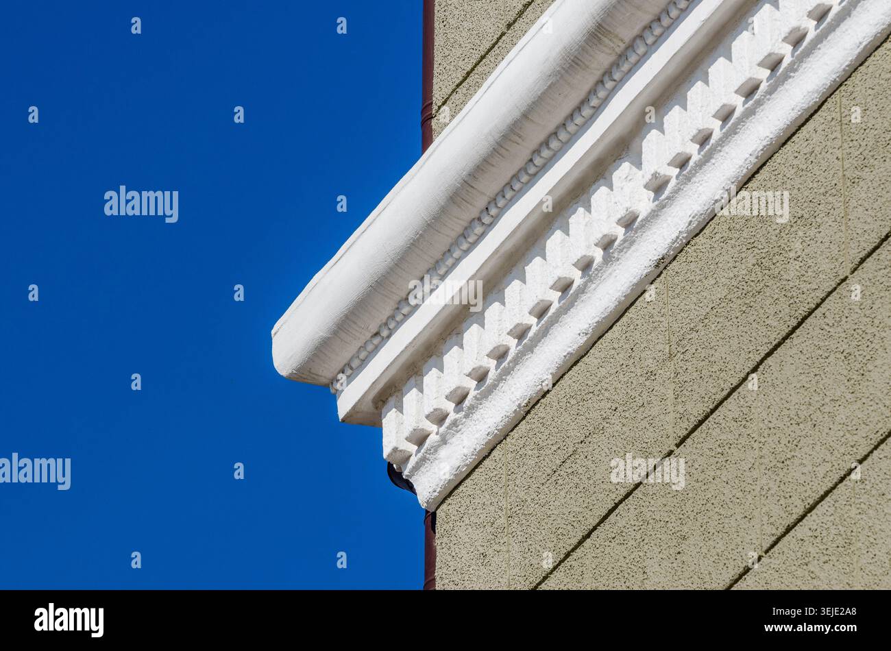 White stucco cornice on a light green plastered cinder block wall Stock Photo