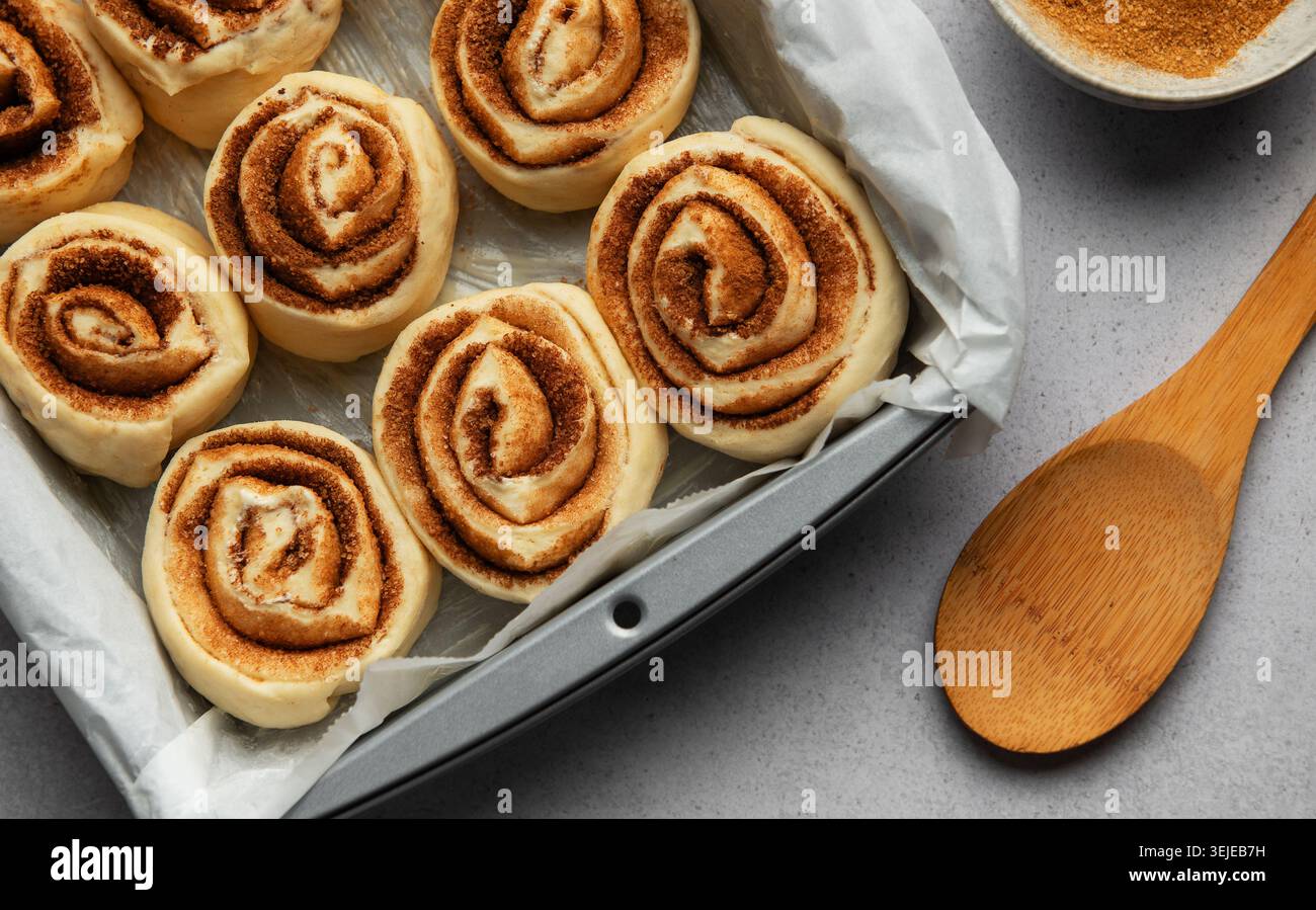 Delicious cinnamon rolls prepared for baking in a rectangular pan Stock Photo