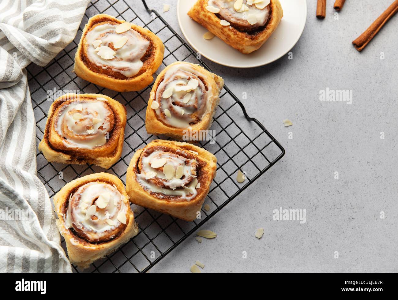 Freshly baked cinnamon rolls cooling on a wire rack Stock Photo