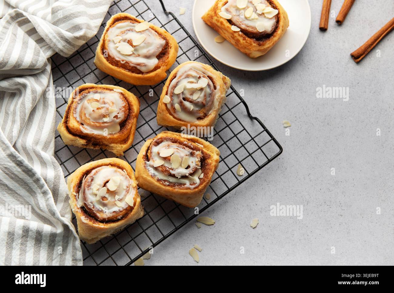 Freshly baked cinnamon rolls cooling on a wire rack Stock Photo
