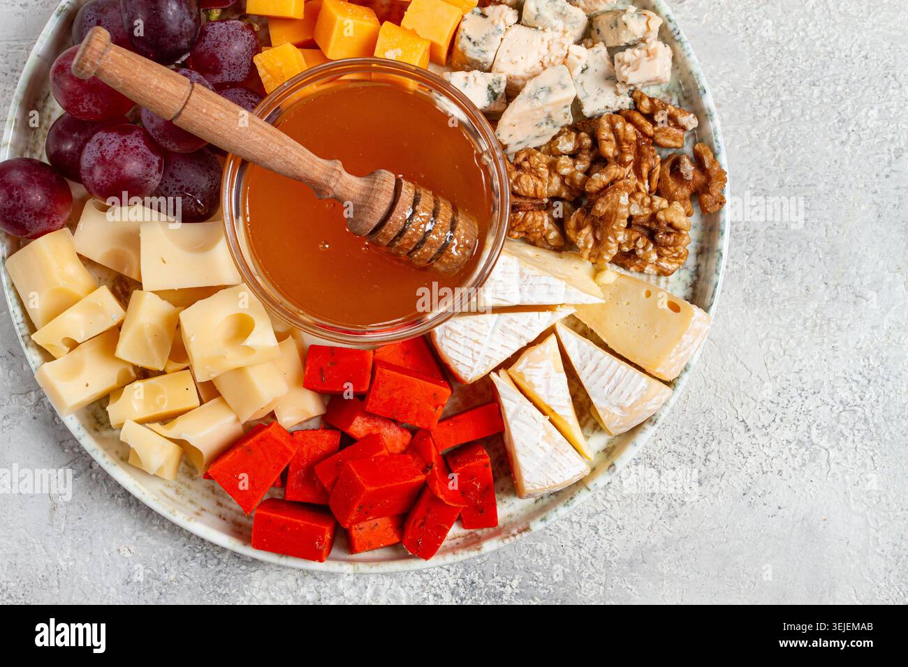 Appetizer, assorted cheese, with nuts and honey, on a round plate, top view, no people, Stock Photo