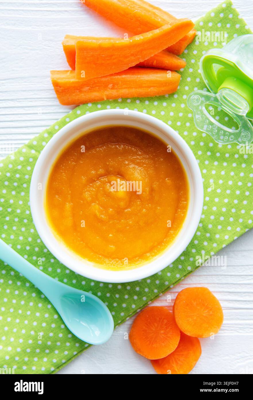 Baby carrot mashed with spoon in bowl Stock Photo