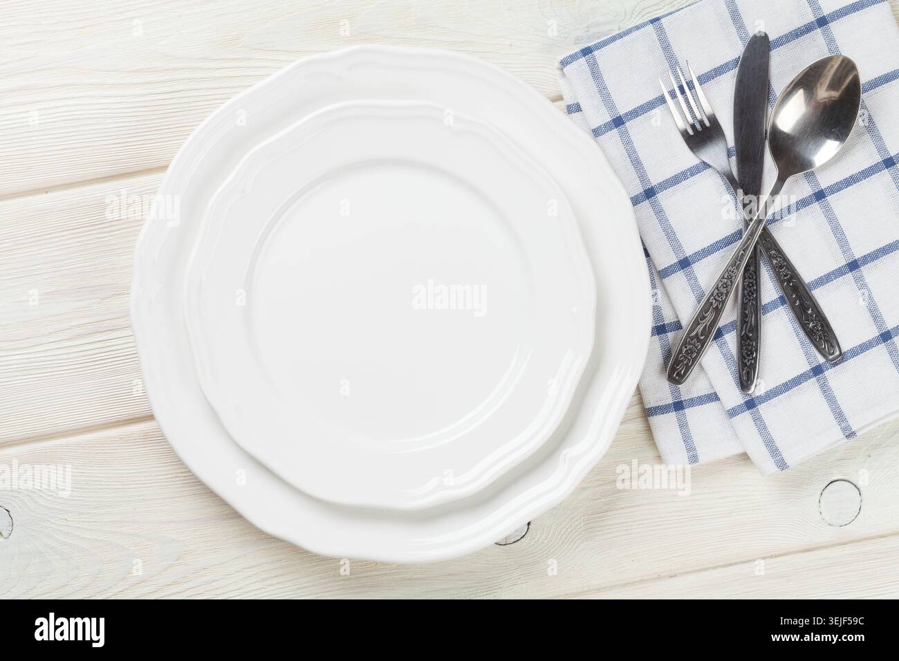 Empty plate and silverware over wooden table Stock Photo