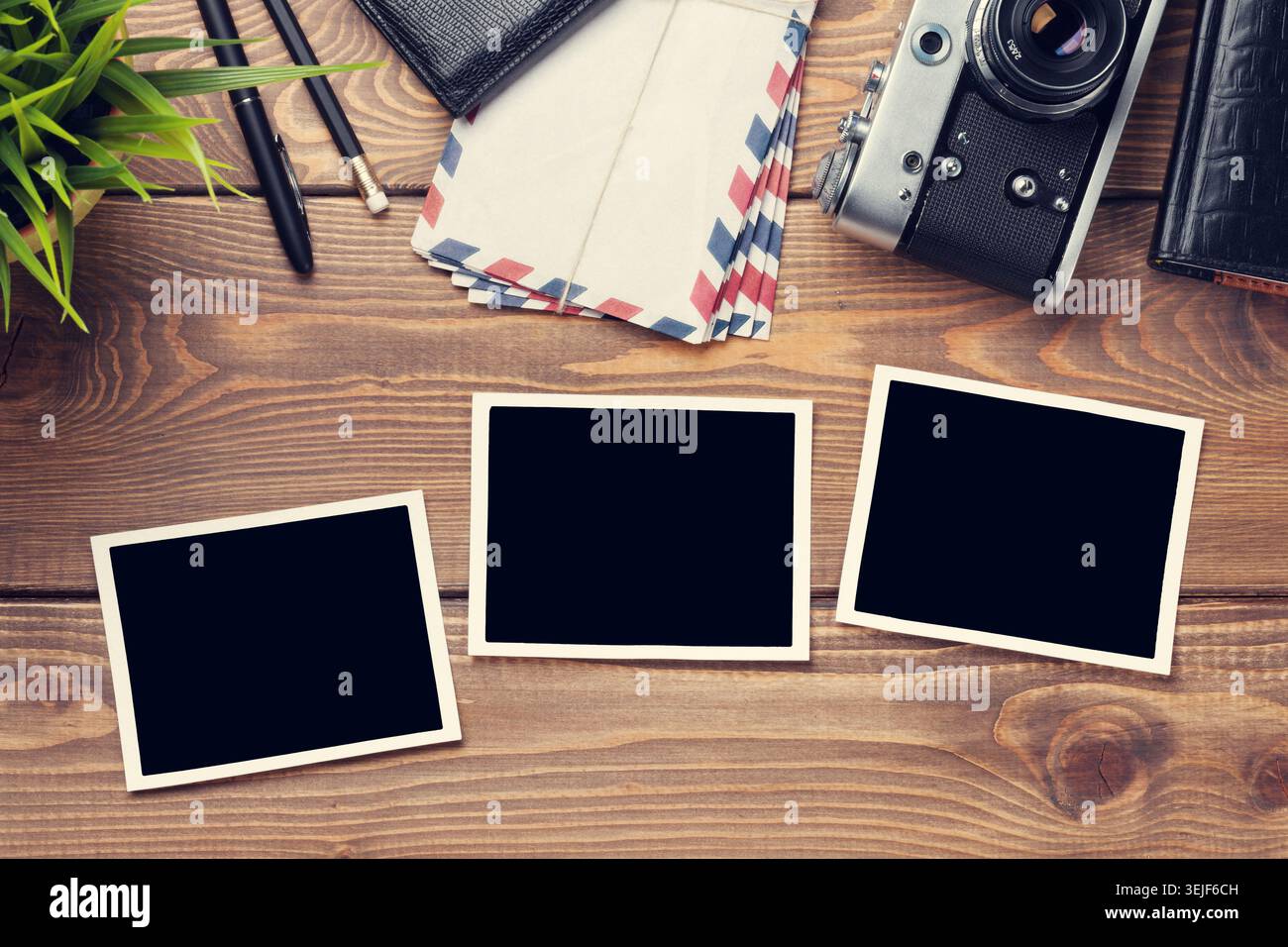 Blank photo frames, camera and supplies on table Stock Photo