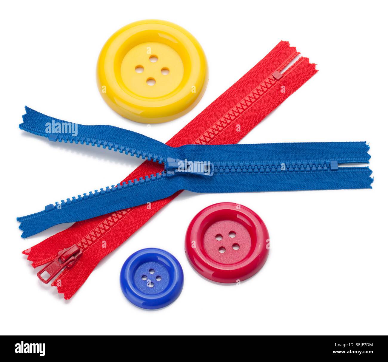 Three colored sewing buttons and two zippers Stock Photo