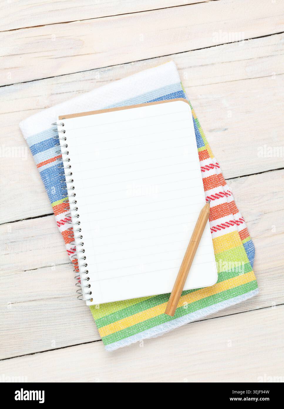 Notepad over kitchen towel on wooden table Stock Photo
