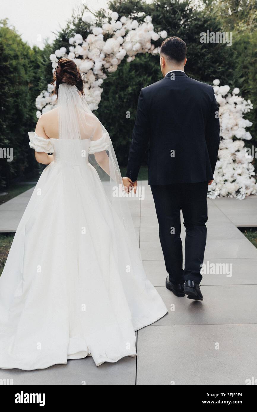 Couple walks hand in hand, back to camera Stock Photo