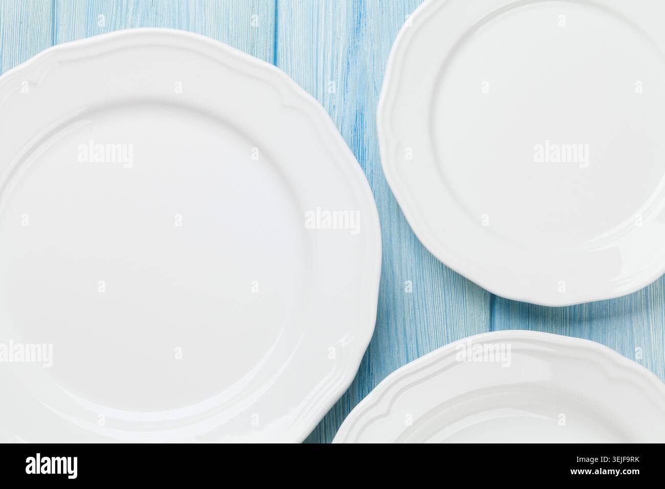 Empty plates over wooden table Stock Photo
