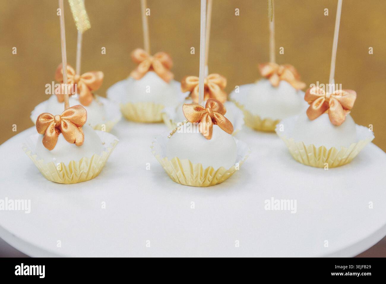 Delicate cake pops sit on a white plate Stock Photo