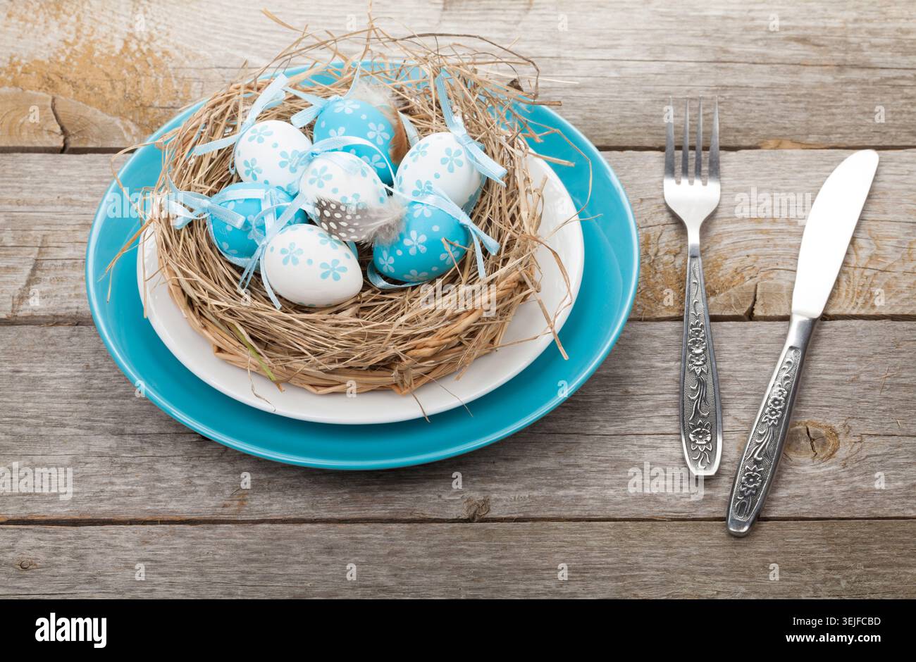 Easter eggs nest on plate over wooden background Stock Photo