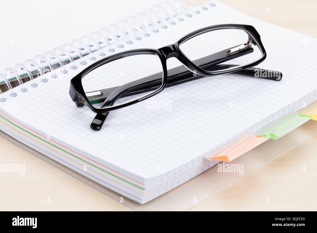 Office table with glasses over notepad Stock Photo