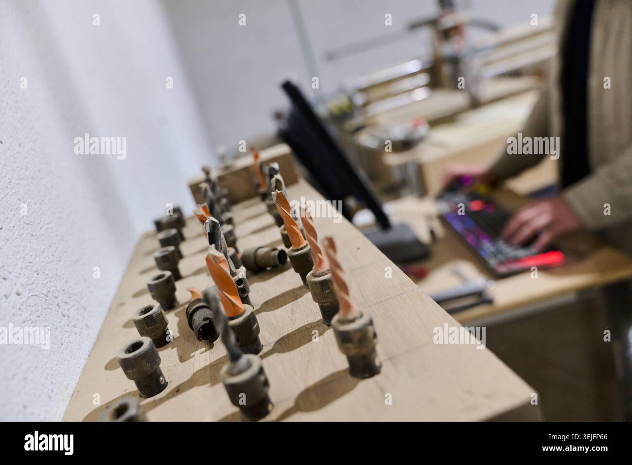 Operator Entering Coordinates on Computer for CNC Machine to Precisely Cut Wooden Pieces Stock Photo