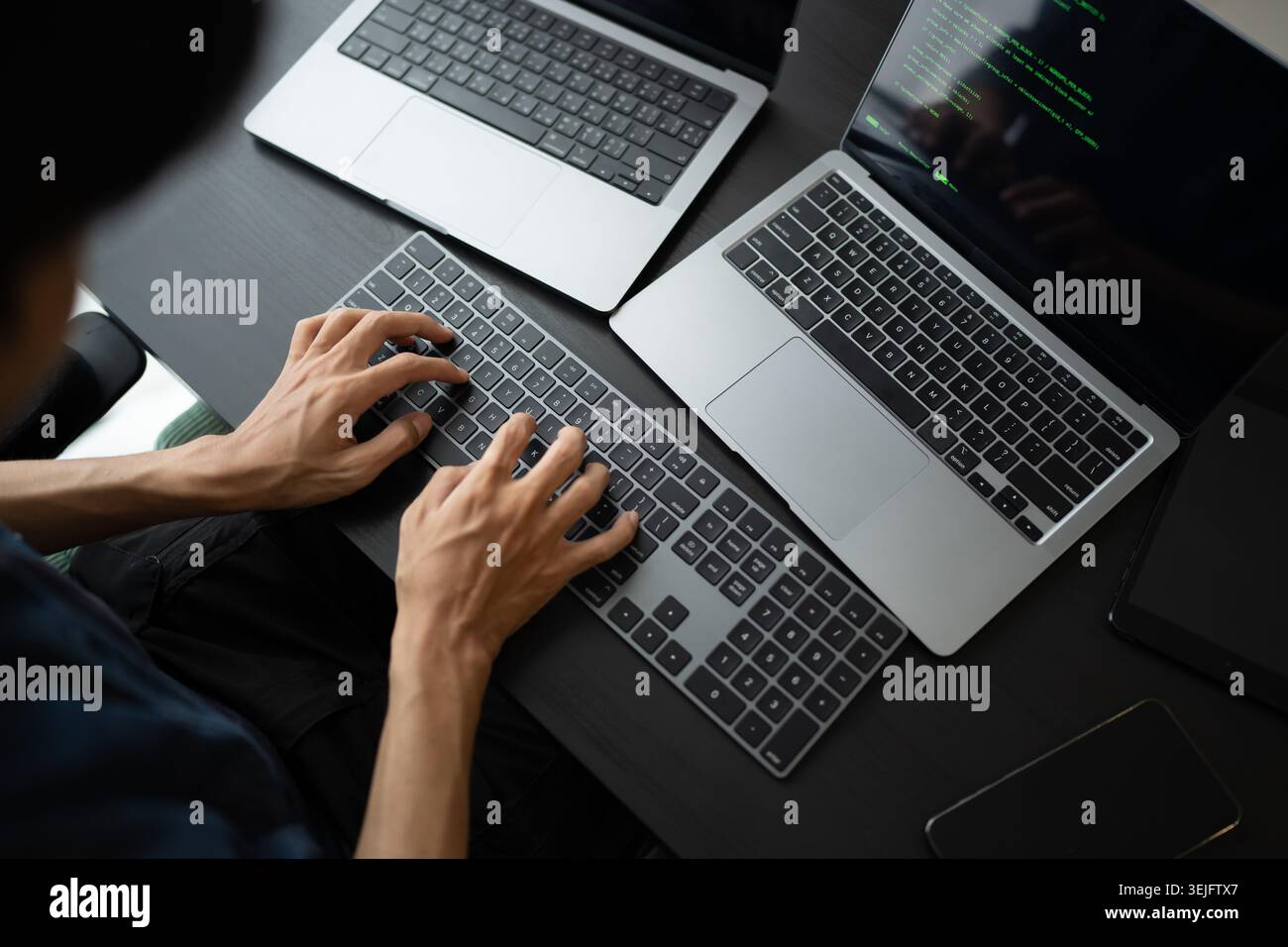 Asian man software engineer Working on Computer at office desk for writing program code IT Software Engineer finding errors tech support devops creati Stock Photo