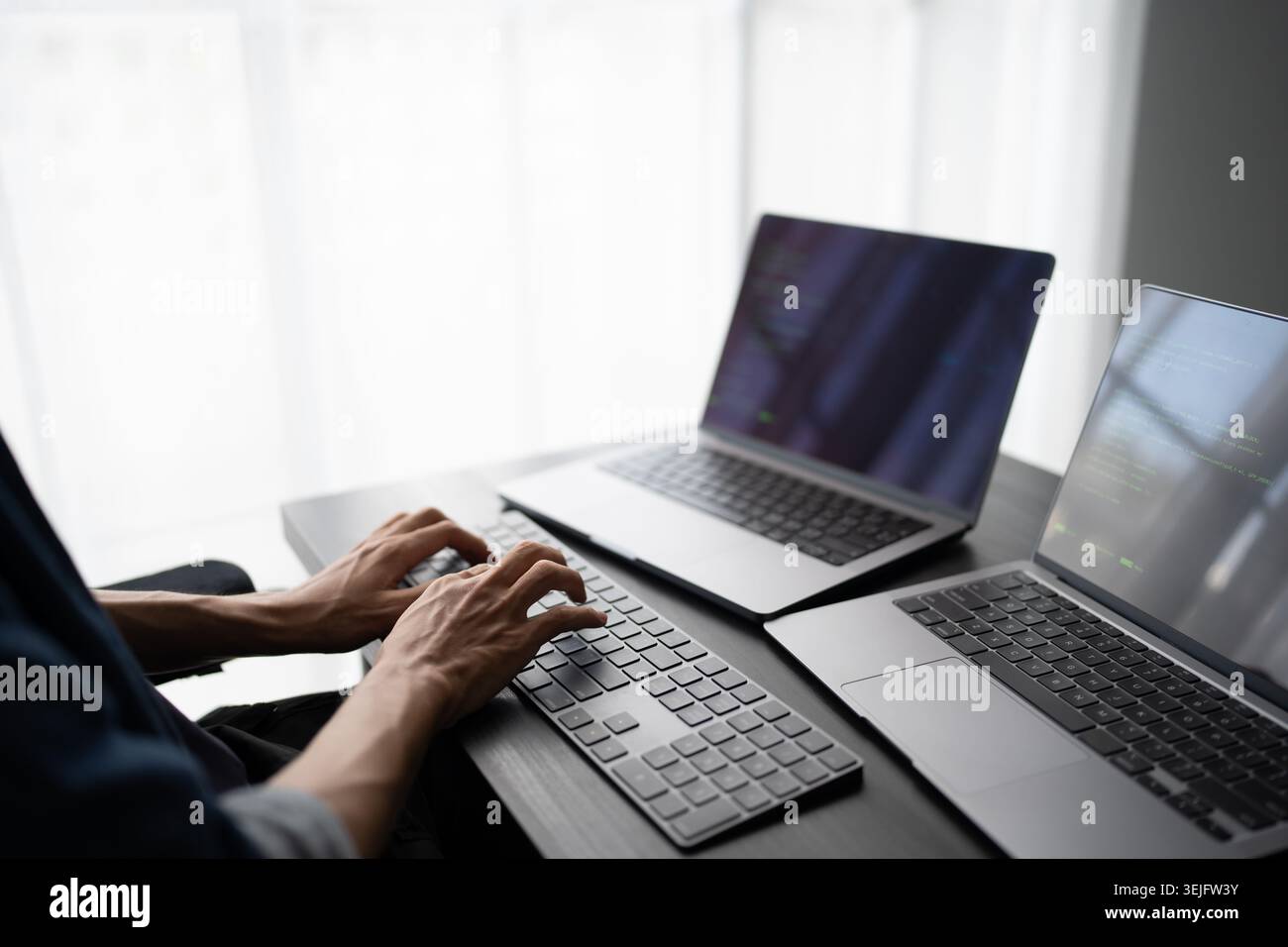 Asian man software engineer Working on Computer at office desk for writing program code IT Software Engineer finding errors tech support devops creati Stock Photo