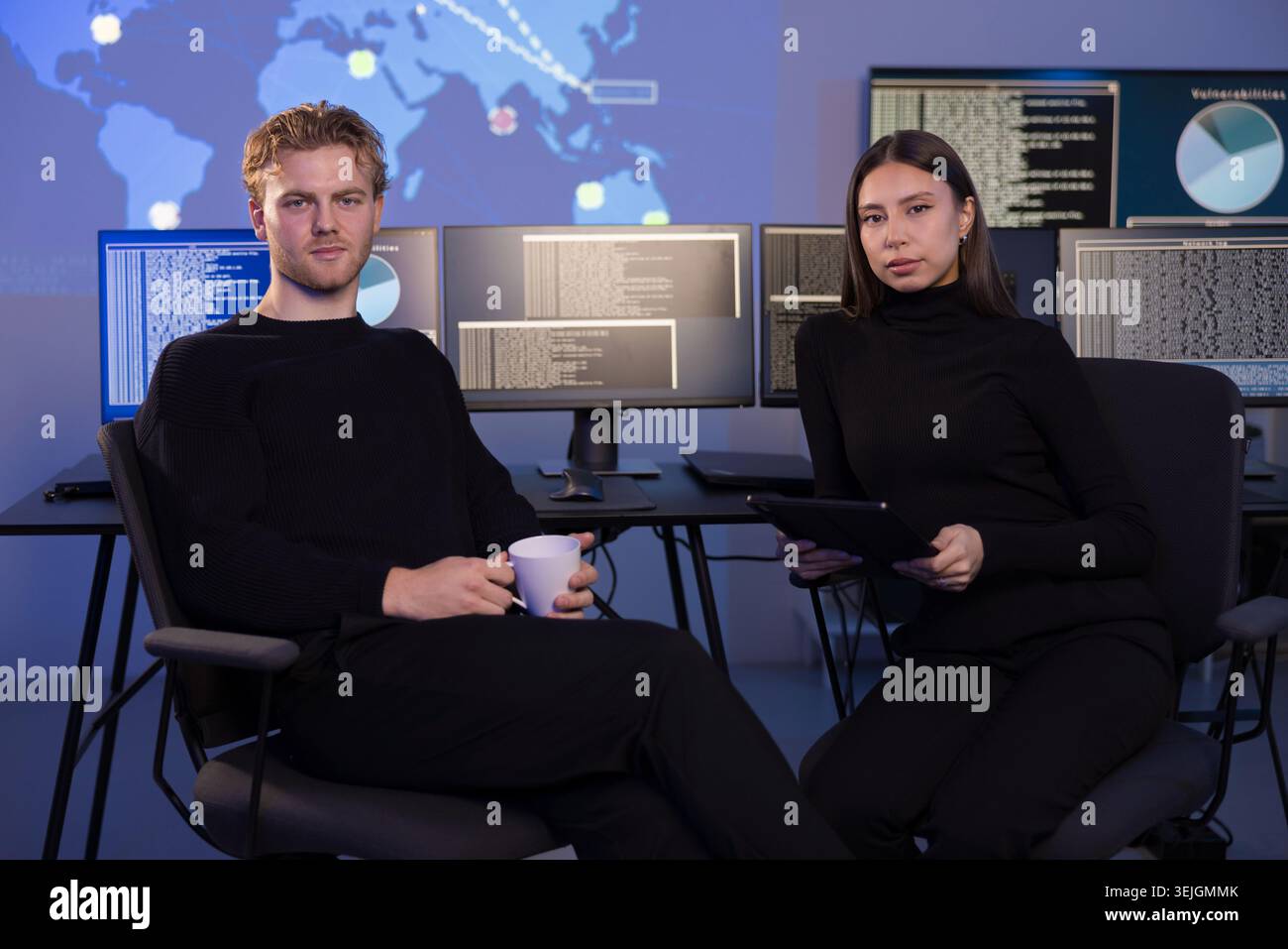 Cyber security team analyzing threats in a modern control room Stock Photo