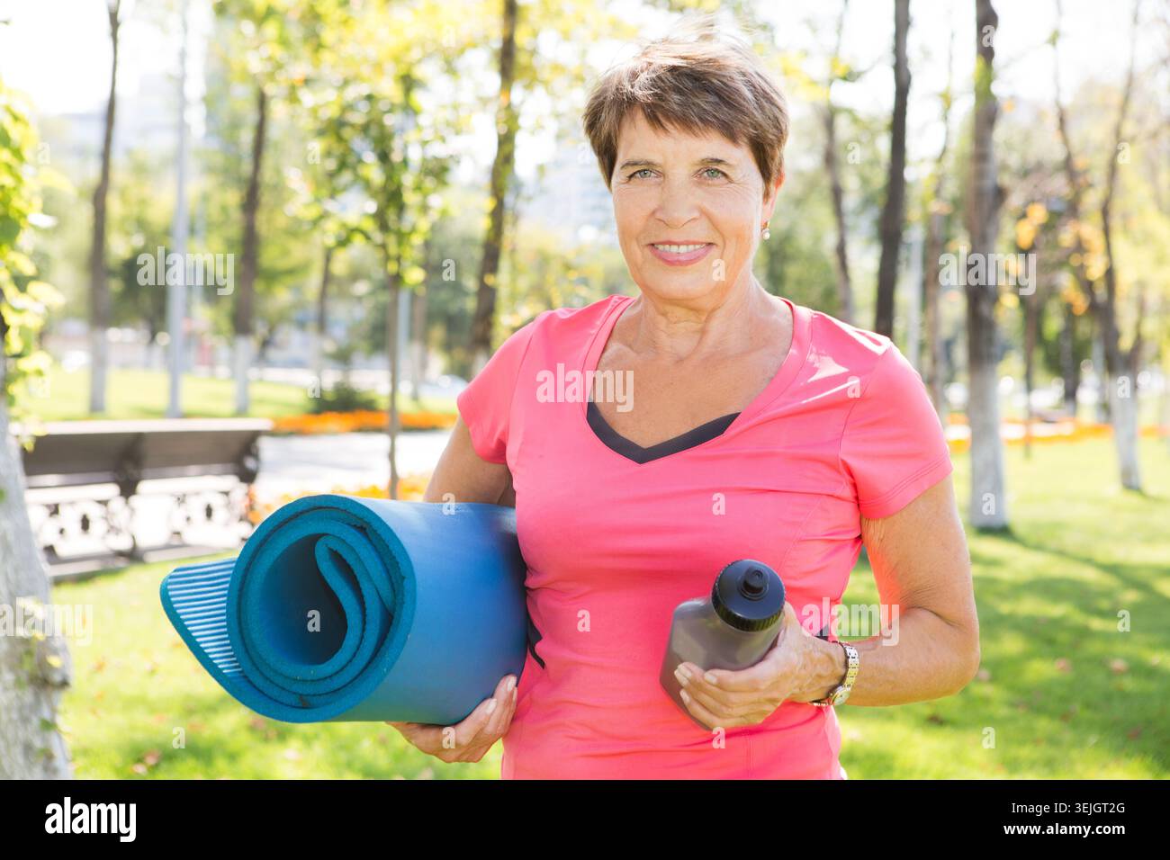 Elderly woman doing exercises outdoors Stock Photo