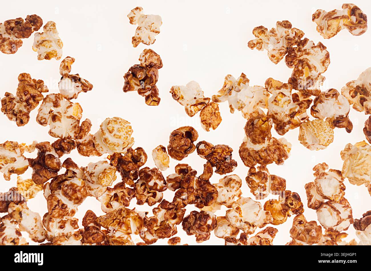 Popcorn with chocolate sauce on white background, top view. Stock Photo