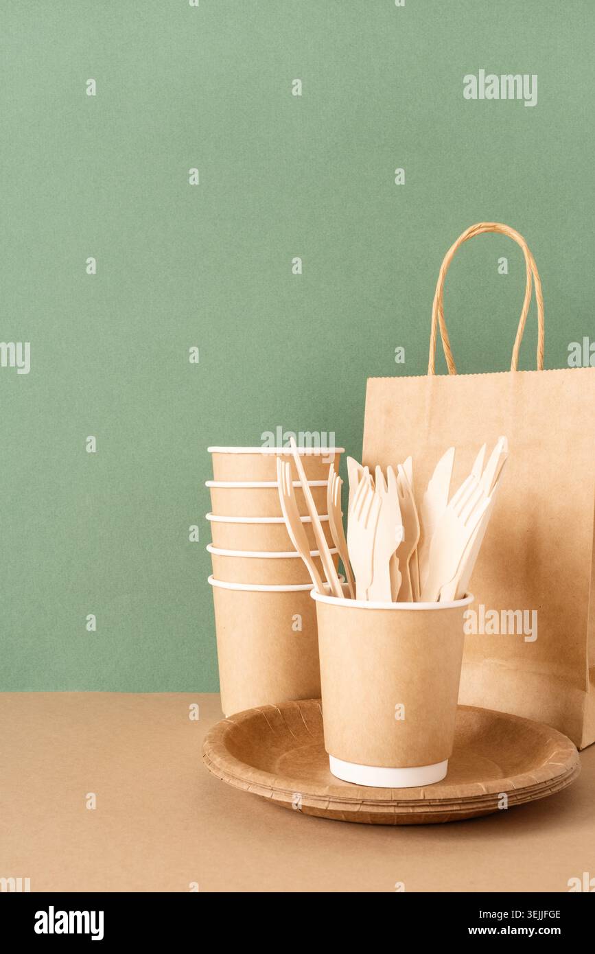 Disposable eco friendly tableware on green background Stock Photo