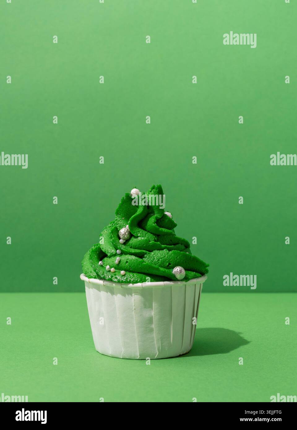 Christmas tree shaped cupcakes on green background Stock Photo