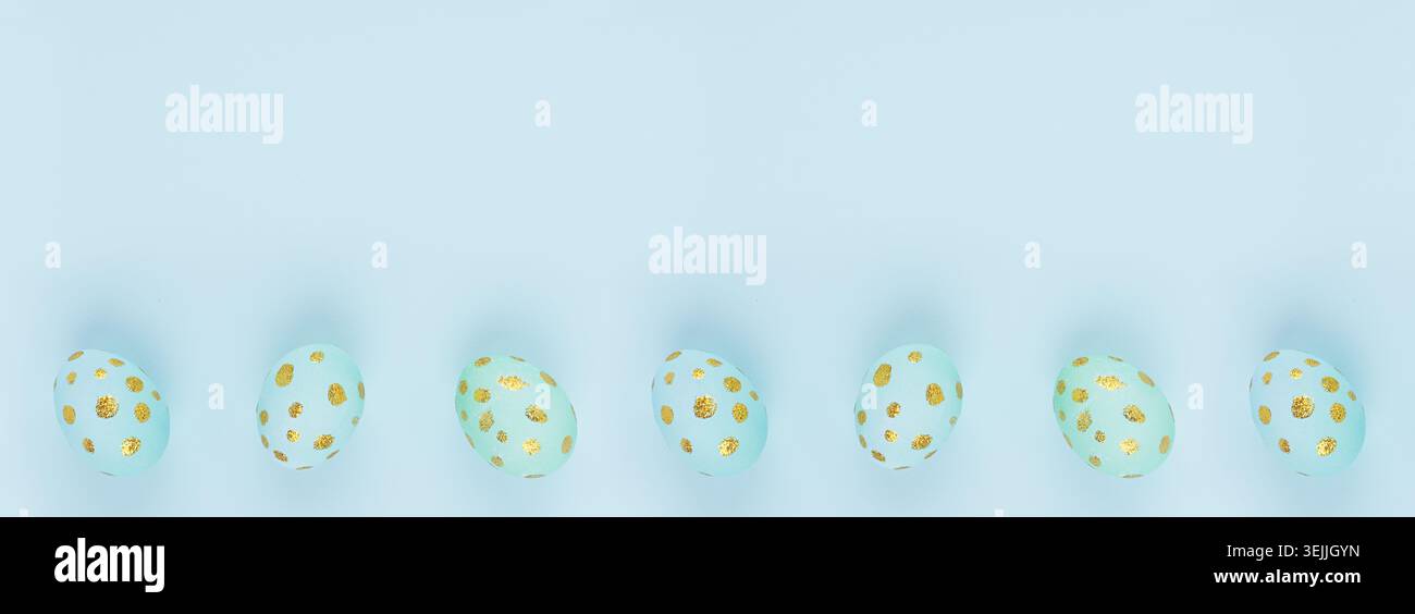 Easter banner - blue eggs with golden dots in row as border on blue backdrop, top view, copy space. Stock Photo