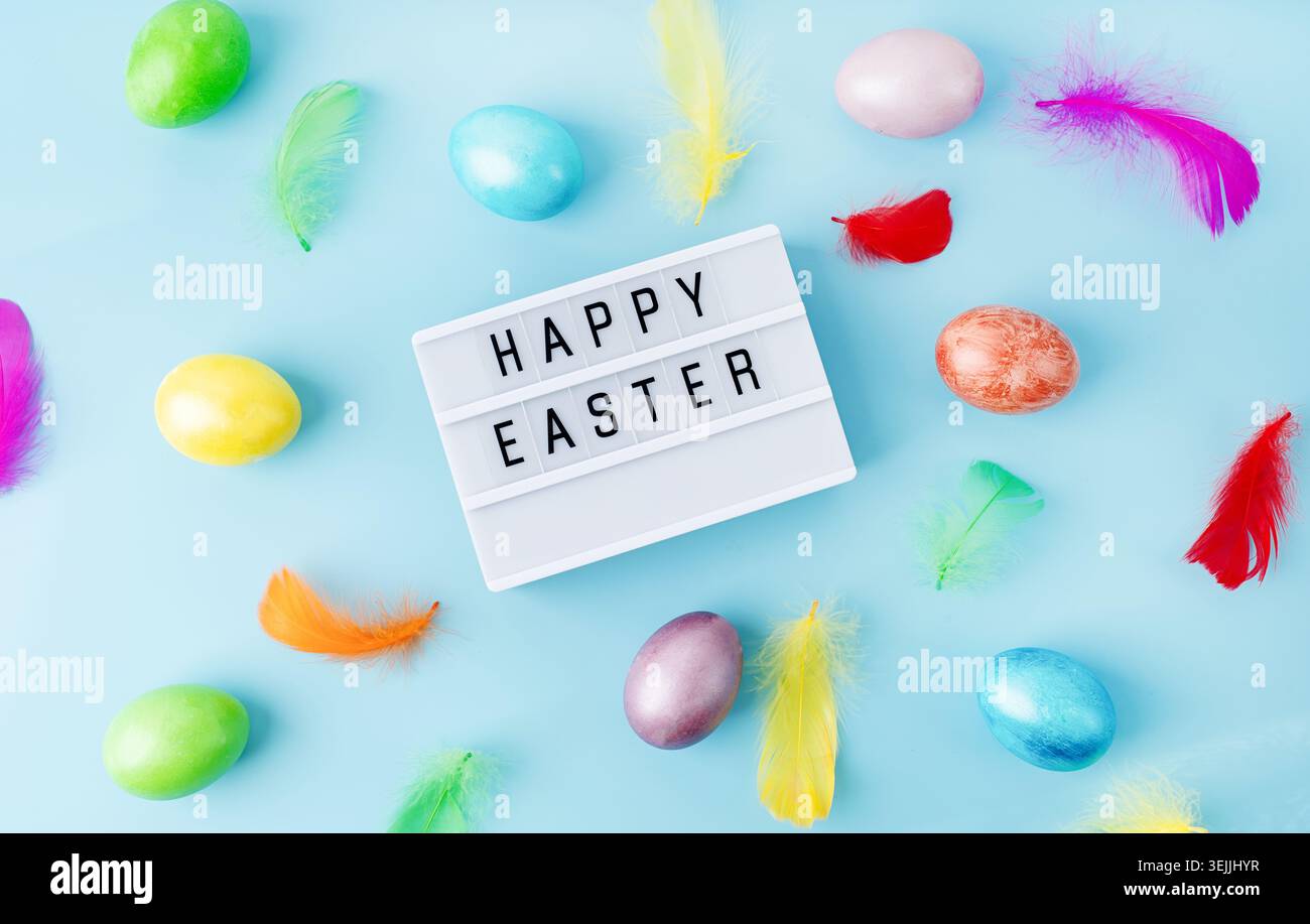 Top view Happy Easter light box decorated with bright colored eggs and feathers Stock Photo