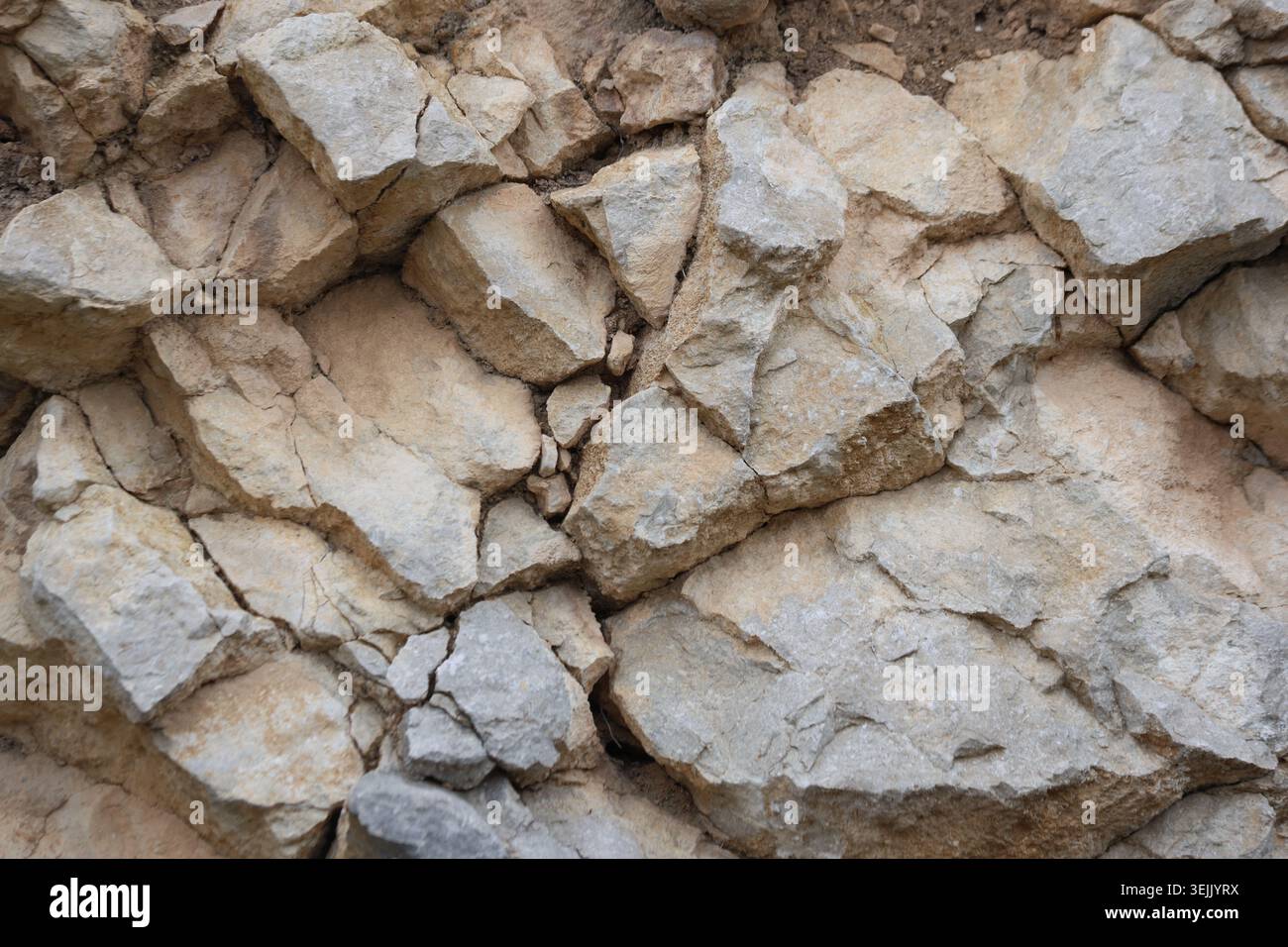 Natural Textured Limestone Rock Surface with Fractures and Angular Cracks Stock Photo