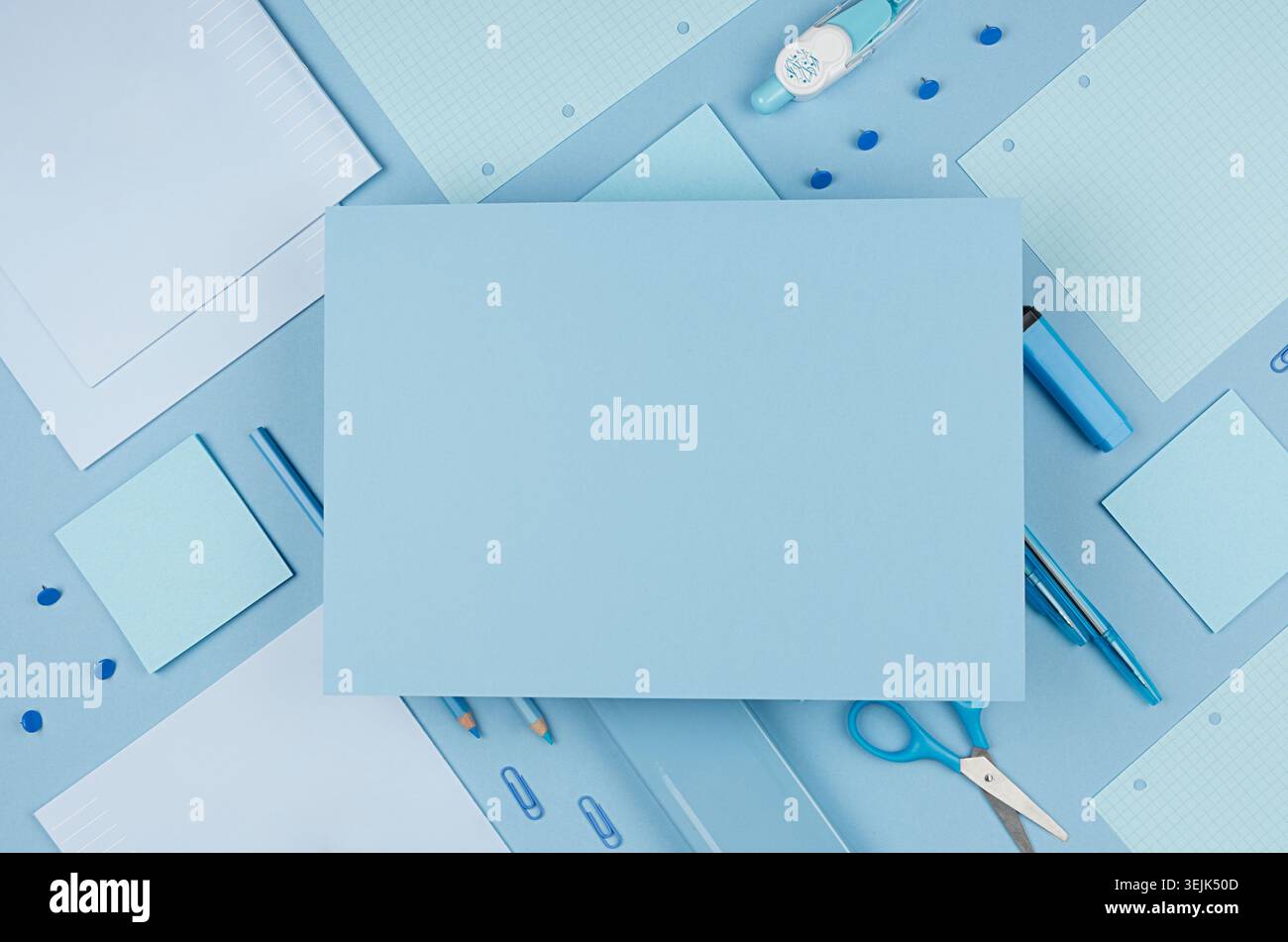 Back to school background - pink boy's different stationery set  and blank paper for text on soft blue paper background. Stock Photo