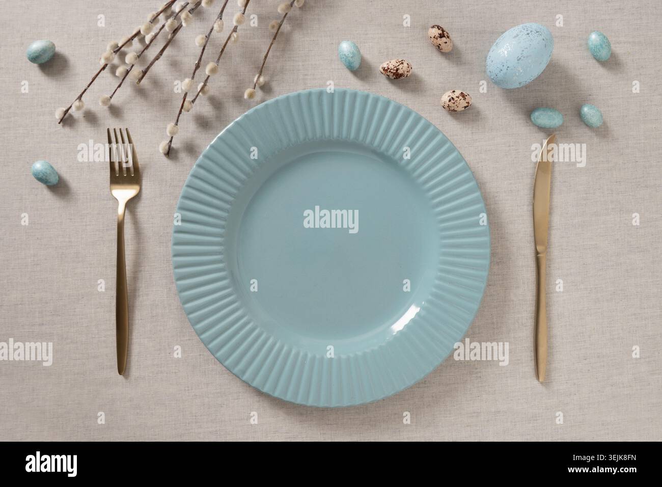 Minimal Easter table setting with empty plate and eggs Stock Photo
