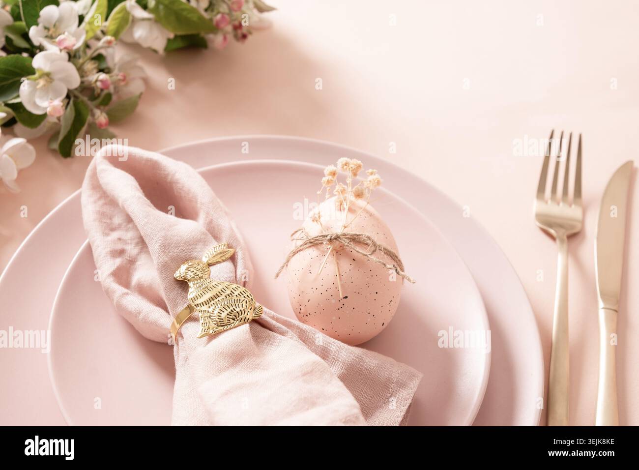Easter egg decoration with golden bunny napkin ring on table setting Stock Photo