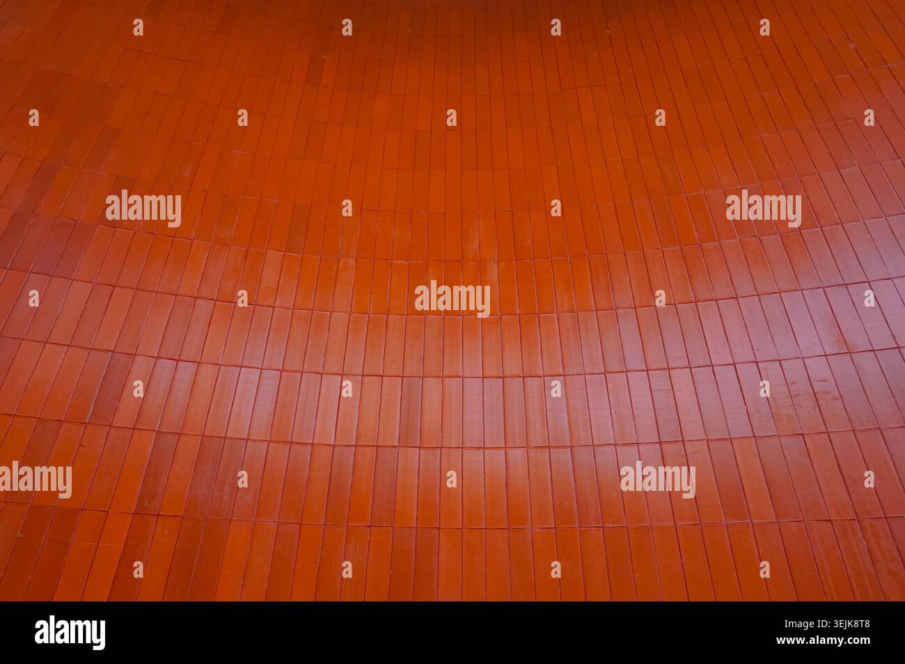 Modern architectural background featuring vertical orange ceramic wall cladding. Stock Photo