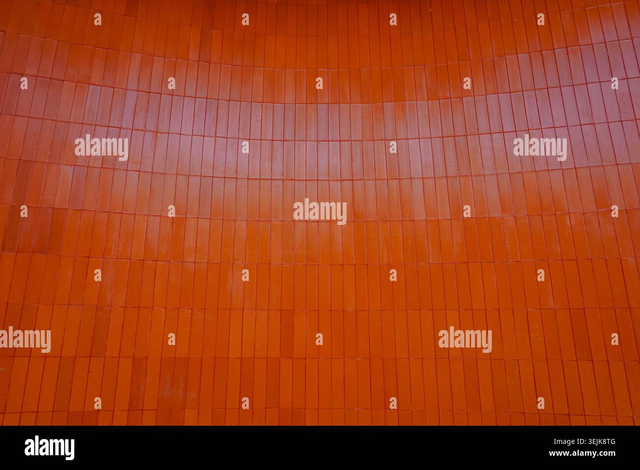 Modern architectural background featuring vertical orange ceramic wall cladding. Stock Photo
