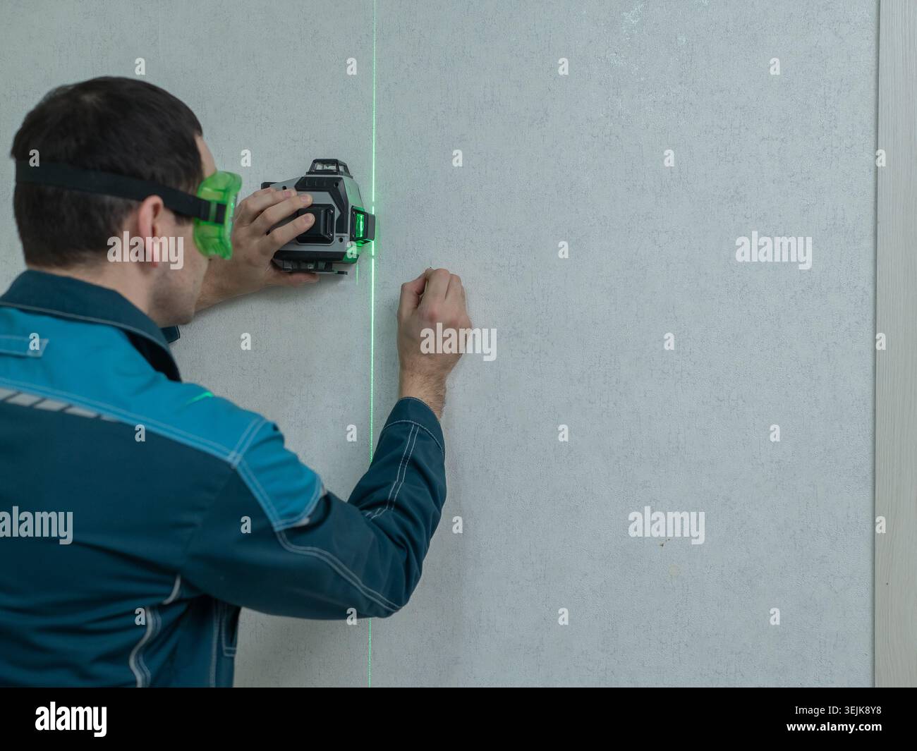 A man measures distance with a laser level.  Stock Photo