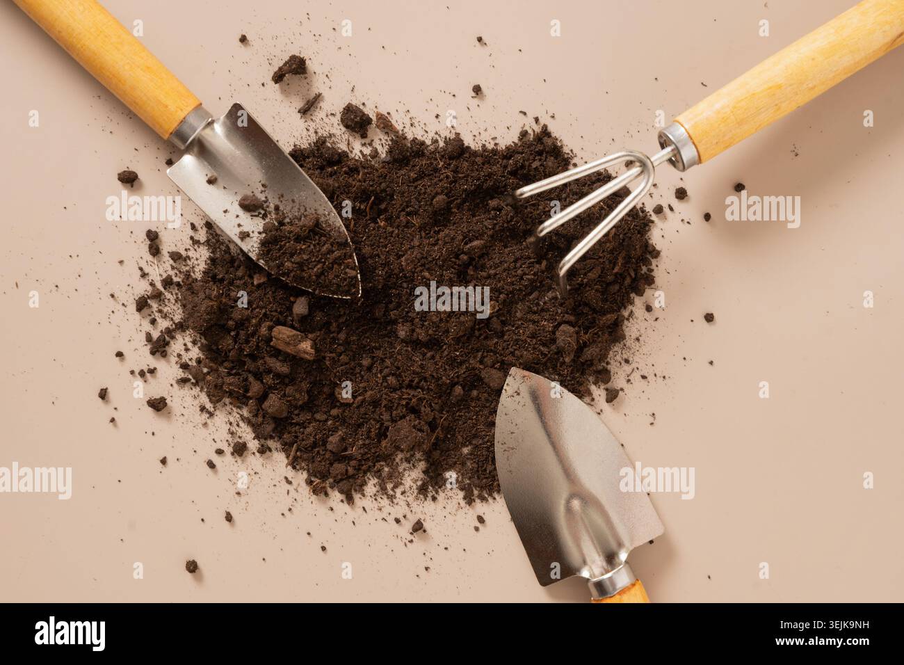 Gardening tools arranged with soil on minimal background Stock Photo
