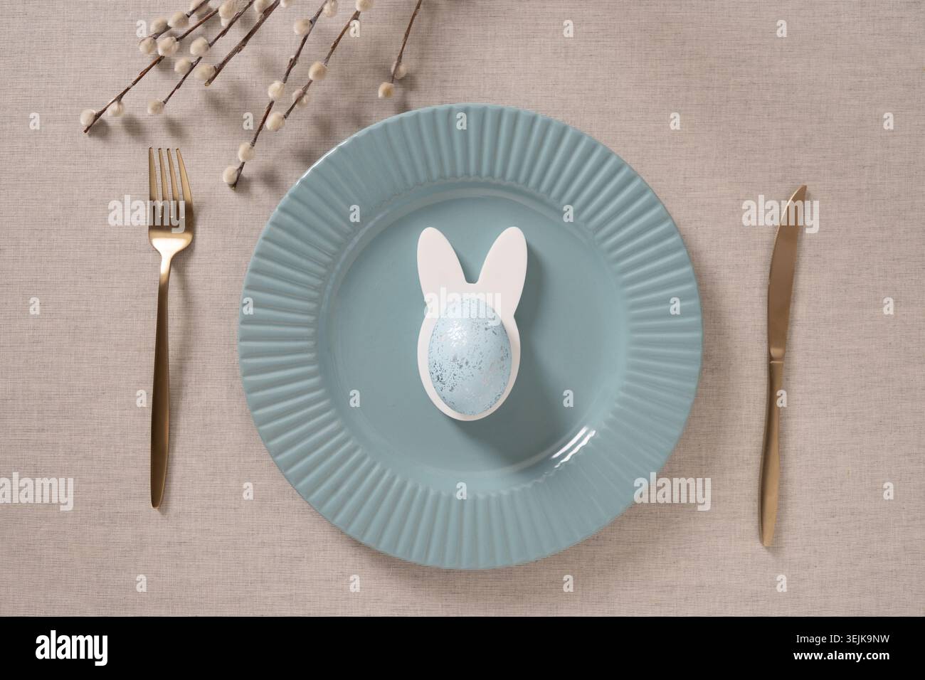 Easter table setting with blue plate and willow branches Stock Photo
