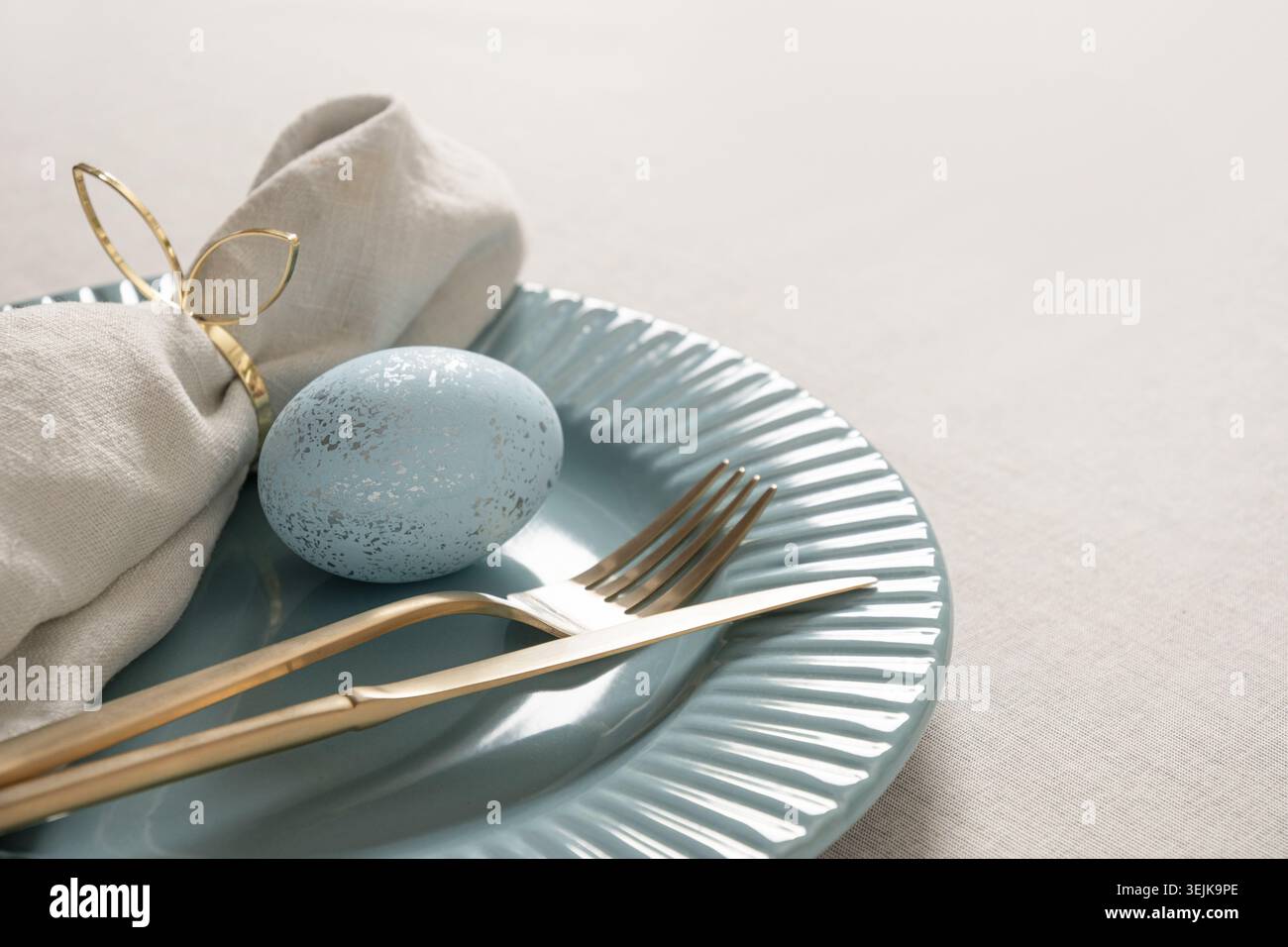 Easter table setting with blue egg and linen napkin Stock Photo
