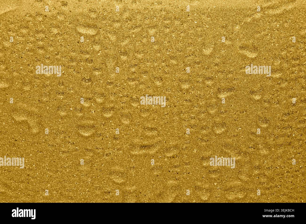 Golden shimmer and glitter wet texture with drops. Rich golden background. Stock Photo