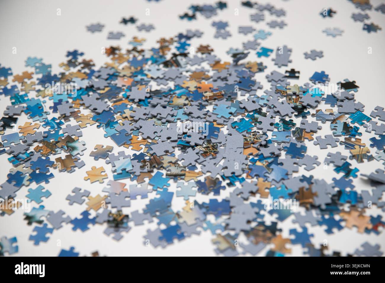 Scattered Blue Jigsaw Puzzle Pieces on White Background Stock Photo