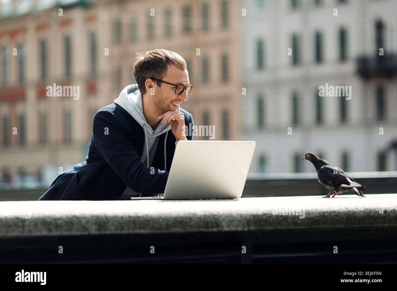 Millennial professional work outside using laptop computer and 5g internet connection. Successful smart casual web developer, designer man happy with Stock Photo