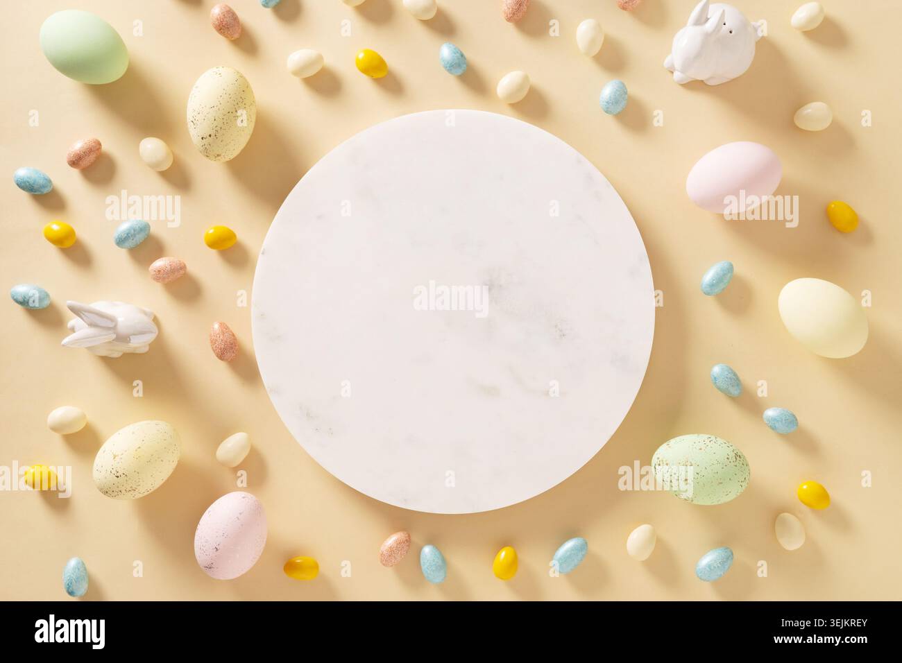 Easter frame with sweet chocolate eggs, painted eggs on yellow. Stock Photo