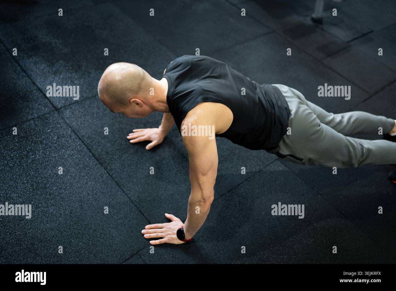 Athletic man doing push ups on gym floor Stock Photo